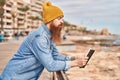 Young redhead man reading book with serious expression at seaside Royalty Free Stock Photo