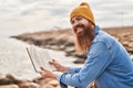 Young redhead man smiling confident reading book at seaside Royalty Free Stock Photo