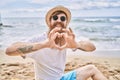 Young redhead man smiling happy doing heart symbol with hands at the beach Royalty Free Stock Photo