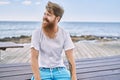 Young redhead man smiling happy sitting on the bench at the beach Royalty Free Stock Photo