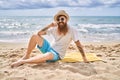 Young redhead man smiling happy sitting on the towel at the beach Royalty Free Stock Photo