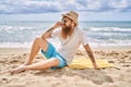 Young redhead man smiling happy sitting on the towel at the beach Royalty Free Stock Photo