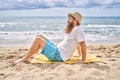 Young redhead man smiling happy sitting on the towel at the beach Royalty Free Stock Photo