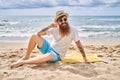 Young redhead man smiling happy sitting on the towel at the beach Royalty Free Stock Photo