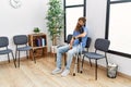 Young redhead man using crutches sitting on the chair at clinic waiting room Royalty Free Stock Photo