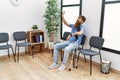 Young redhead man using crutches sitting on the chair at clinic waiting room Royalty Free Stock Photo