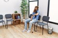 Young redhead man using crutches sitting on the chair at clinic waiting room Royalty Free Stock Photo