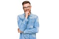 Young redhead man wearing casual denim shirt looking confident at the camera with smile with crossed arms and hand raised on chin Royalty Free Stock Photo