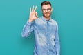 Young redhead man wearing casual denim shirt smiling positive doing ok sign with hand and fingers Royalty Free Stock Photo