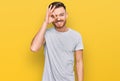 Young redhead man wearing casual grey t shirt doing ok gesture with hand smiling, eye looking through fingers with happy face Royalty Free Stock Photo