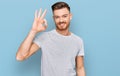 Young redhead man wearing casual grey t shirt smiling positive doing ok sign with hand and fingers Royalty Free Stock Photo