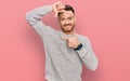 Young redhead man wearing casual winter sweater smiling making frame with hands and fingers with happy face Royalty Free Stock Photo