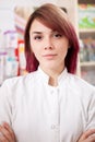 Young redhead pharmacist in front of her desk