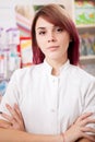Young redhead pharmacist in front of her desk