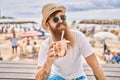 Young redhead tourist man drinking cocktail sitting on the bench at the beach Royalty Free Stock Photo