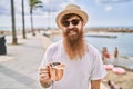 Young redhead tourist man smiling happy drinking cocktail at the beach Royalty Free Stock Photo