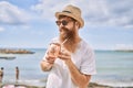 Young redhead tourist man smiling happy drinking cocktail at the beach Royalty Free Stock Photo