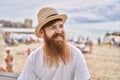 Young redhead tourist man smiling happy sitting on the bench at the beach Royalty Free Stock Photo