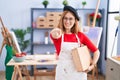 Young redhead woman at art studio holding art case pointing to you and the camera with fingers, smiling positive and cheerful Royalty Free Stock Photo