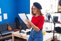 Young redhead woman artist smiling confident reading music sheet at music studio Royalty Free Stock Photo