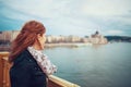 Young redhead woman at autumn take pleasure in Budapest cityscape