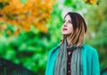 Woman in blue coat resting in autum park