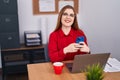 Young redhead woman business worker using laptop and smartphone at office Royalty Free Stock Photo