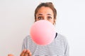 Young redhead woman chewing gum and blowing hair bubble over white isolated background cover mouth with hand shocked with shame Royalty Free Stock Photo