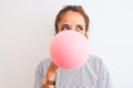 Young redhead woman chewing gum and blowing hair bubble over white isolated background serious face thinking about question, very Royalty Free Stock Photo