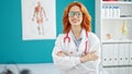 Young redhead woman doctor smiling confident standing with arms crossed gesture at clinic Royalty Free Stock Photo