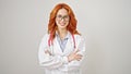 Young redhead woman doctor smiling confident standing with arms crossed gesture over isolated white background Royalty Free Stock Photo