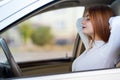 Young redhead woman driver fastened by seatbelt resting in a car smiling happily Royalty Free Stock Photo