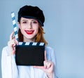 Young redhead woman in hat holding movie clapboard Royalty Free Stock Photo