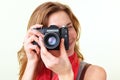 Young redhead woman looking through viewfinder with an old 35mm slr camera Royalty Free Stock Photo