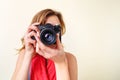 Young redhead woman looking through viewfinder with an old 35mm slr camera Royalty Free Stock Photo