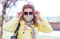 Young redhead woman in mask holding sungalsses at springtime Royalty Free Stock Photo