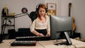 Young redhead woman musician playing piano keyboard at music studio Royalty Free Stock Photo