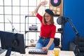 Young redhead woman musician smiling confident having dj session at music studio Royalty Free Stock Photo
