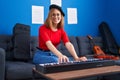 Young redhead woman musician smiling confident playing piano at music studio Royalty Free Stock Photo