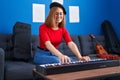 Young redhead woman musician smiling confident playing piano at music studio Royalty Free Stock Photo