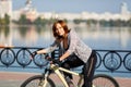 Young redhead woman riding a bike on embankment. Active people outdoors. Sport lifestyle. Royalty Free Stock Photo