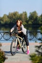 Young redhead woman riding a bike on embankment. Active people outdoors. Sport lifestyle. Royalty Free Stock Photo