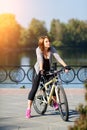 Young redhead woman riding a bike on embankment. Active people outdoors. Sport lifestyle. Royalty Free Stock Photo