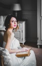 Young redhead woman sitting in chair reading book. Royalty Free Stock Photo