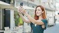 Young redhead woman smiling confident making selfie by the smartphone at coffee shop terrace Royalty Free Stock Photo