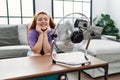 Young redhead woman smiling confident using electric ventilator at home