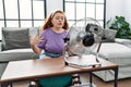 Young redhead woman using electric ventilator at home