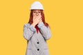 Young redhead woman wearing architect hardhat shocked covering mouth with hands for mistake Royalty Free Stock Photo