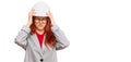 Young redhead woman wearing architect hardhat suffering from headache desperate and stressed because pain and migraine Royalty Free Stock Photo