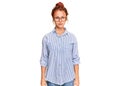 Young redhead woman wearing casual clothes and glasses with serious expression on face Royalty Free Stock Photo